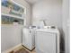 Bright laundry room features modern white Samsung washer and dryer appliances under a window at 1857 W 67Th Pl, Denver, CO 80221
