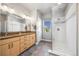 Bright main bathroom with dual sinks, a walk-in shower, and a window view at 1857 W 67Th Pl, Denver, CO 80221
