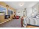 Comfortable main bedroom featuring a red chair, fireplace, and ample natural light at 1857 W 67Th Pl, Denver, CO 80221