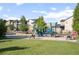 A vibrant neighborhood playground offers play equipment, a lush green lawn, and nearby townhomes at 1857 W 67Th Pl, Denver, CO 80221