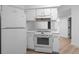 Clean white kitchen featuring marble countertops, white cabinets, and updated appliances at 4552 S Buckley Way, Aurora, CO 80015