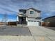 Charming two-story home featuring stone accents, a two-car garage, and a well-maintained lawn at 9446 Yampa Ct, Commerce City, CO 80022