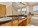 Bright bathroom with double sinks, a spacious vanity, and a soaking tub under a scenic window at 481 Sunrise Dr, Golden, CO 80401