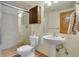 Well lit bathroom featuring earth tone tile, glass shower door and pedestal sink at 481 Sunrise Dr, Golden, CO 80401