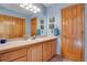 Well-lit bathroom with a wide vanity, wood-paneled door, and blue walls at 481 Sunrise Dr, Golden, CO 80401