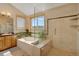 Luxurious bathroom with a soaking tub, tiled shower, and scenic window view at 481 Sunrise Dr, Golden, CO 80401