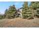 Home exterior featuring mature trees, a balcony, and a walkout lower level at 481 Sunrise Dr, Golden, CO 80401