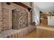 Close up of the ornate brick fireplace with hardwood floors, detailed metal screen, and access to the dining area at 481 Sunrise Dr, Golden, CO 80401