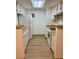 Well-lit kitchen with white cabinets, modern appliances, and laminate wood floors at 4400 S Quebec St # 102R, Denver, CO 80237