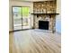 Spacious living room with a stone fireplace and sliding glass doors to a balcony at 4400 S Quebec St # 102R, Denver, CO 80237