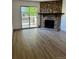 Cozy living room featuring hardwood floors, a stone fireplace, and a sliding door leading to the balcony at 4400 S Quebec St # 102R, Denver, CO 80237