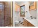 Well-lit bathroom featuring a shower stall with mosaic tile, and wood cabinets at 29011 Upper Moss Rock Rd, Golden, CO 80401