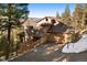 View of the house with a stone chimney and an attached garage at 29011 Upper Moss Rock Rd, Golden, CO 80401