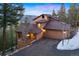 View of the house with a stone chimney and an attached garage, at dusk at 29011 Upper Moss Rock Rd, Golden, CO 80401