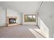 Bright living room with a fireplace, large window, and neutral decor, perfect for relaxation and gatherings at 29011 Upper Moss Rock Rd, Golden, CO 80401