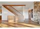 Inviting living room with wood floors, natural light, wood-burning fireplace, staircase and attractive entry door at 29011 Upper Moss Rock Rd, Golden, CO 80401