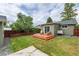 Spacious backyard featuring a wooden deck with seating, concrete area and mature trees at 4520 S Delaware St, Englewood, CO 80110