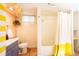 Bright bathroom featuring modern fixtures, a shower with a white and yellow curtain, and a window at 4520 S Delaware St, Englewood, CO 80110