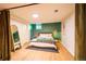 Bright bedroom featuring a comfortable bed, green accent wall, and stylish decor at 4520 S Delaware St, Englewood, CO 80110