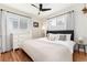 Bedroom featuring a bed with soft linens, a ceiling fan, and natural light through large windows at 4520 S Delaware St, Englewood, CO 80110