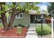 Charming home featuring a landscaped front yard with a tree and concrete steps leading to the front entrance at 4520 S Delaware St, Englewood, CO 80110