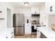 Well-lit kitchen with stainless steel appliances, white cabinets, light countertops and tile backsplash at 4520 S Delaware St, Englewood, CO 80110
