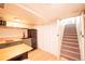 A cozy kitchenette with modern appliances, wood countertop, and stairs to the side at 4520 S Delaware St, Englewood, CO 80110