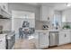 Bright kitchen with white cabinets, stainless steel appliances, and adjacent dining area with wood floors at 4520 S Delaware St, Englewood, CO 80110