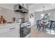 Eat-in kitchen featuring modern appliances, white cabinets, and a view to the dining area at 4520 S Delaware St, Englewood, CO 80110