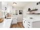 Bright kitchen with white cabinets, hardwood floors, quartz countertops, and stainless steel sink at 4520 S Delaware St, Englewood, CO 80110