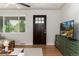 Bright living room featuring hardwood floors, large window, and a modern TV and console at 4520 S Delaware St, Englewood, CO 80110