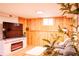 Comfortable living room area with wood paneling and modern entertainment center at 4520 S Delaware St, Englewood, CO 80110
