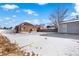 Large backyard with detached garage and snow-covered ground at 501 S Dale Ct, Denver, CO 80219