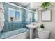 Modern bathroom with blue tile, a glass shower, and a pedestal sink at 501 S Dale Ct, Denver, CO 80219