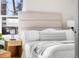 Bright bedroom with a neutral upholstered headboard and a wooden nightstand at 501 S Dale Ct, Denver, CO 80219