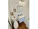 Quaint bathroom with white vanity, framed botanical wall art, and toilet at 4036 S Himalaya Cir, Aurora, CO 80013