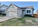Charming home featuring a manicured front yard, attached garage, and stylish brick and siding exterior at 4036 S Himalaya Cir, Aurora, CO 80013