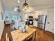 An inviting kitchen with stainless steel appliances, white cabinets, and a dining area bathed in natural light at 4036 S Himalaya Cir, Aurora, CO 80013