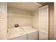 A small laundry room includes a side-by-side washer and dryer with built in shelving at 2162 Concord Ln, Superior, CO 80027