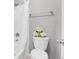 Bathroom features a toilet and a bathtub-shower combination with white decorative flowers at 14242 E Hawaii Cir # C, Aurora, CO 80012