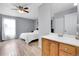 Bathroom featuring wood vanity with a large mirror and a bedroom with a ceiling fan beyond at 14242 E Hawaii Cir # C, Aurora, CO 80012