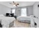 Light-filled bedroom featuring two beds, a ceiling fan, and wood-look floors at 14242 E Hawaii Cir # C, Aurora, CO 80012