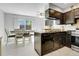 Bright kitchen with stainless steel appliances, tile flooring, dark cabinetry and dining area with sliding glass door at 14242 E Hawaii Cir # C, Aurora, CO 80012