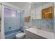 Cozy bathroom featuring blue tile, a bathtub, and a sink with a mirrored cabinet at 920 Emerson Cir, Northglenn, CO 80233