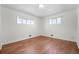 Clean, minimalist bedroom featuring hardwood floors, neutral walls, and natural light from two windows at 920 Emerson Cir, Northglenn, CO 80233