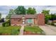 Charming brick home featuring a manicured lawn, complemented by mature trees, and a cozy front entrance at 920 Emerson Cir, Northglenn, CO 80233