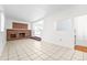 Open living area with tile flooring, a brick fireplace, and steps to a bright adjoining space at 920 Emerson Cir, Northglenn, CO 80233