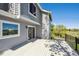 Back deck with grey siding, sliding glass doors, metal railings, and scenic views of trees and sky at 9728 Ashleigh Ln, Highlands Ranch, CO 80126