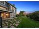 Exterior view of a home featuring a large yard, patio, and deck at dusk at 9728 Ashleigh Ln, Highlands Ranch, CO 80126