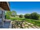 Backyard with green lawn, bushes, and a stone paver patio area at 9728 Ashleigh Ln, Highlands Ranch, CO 80126